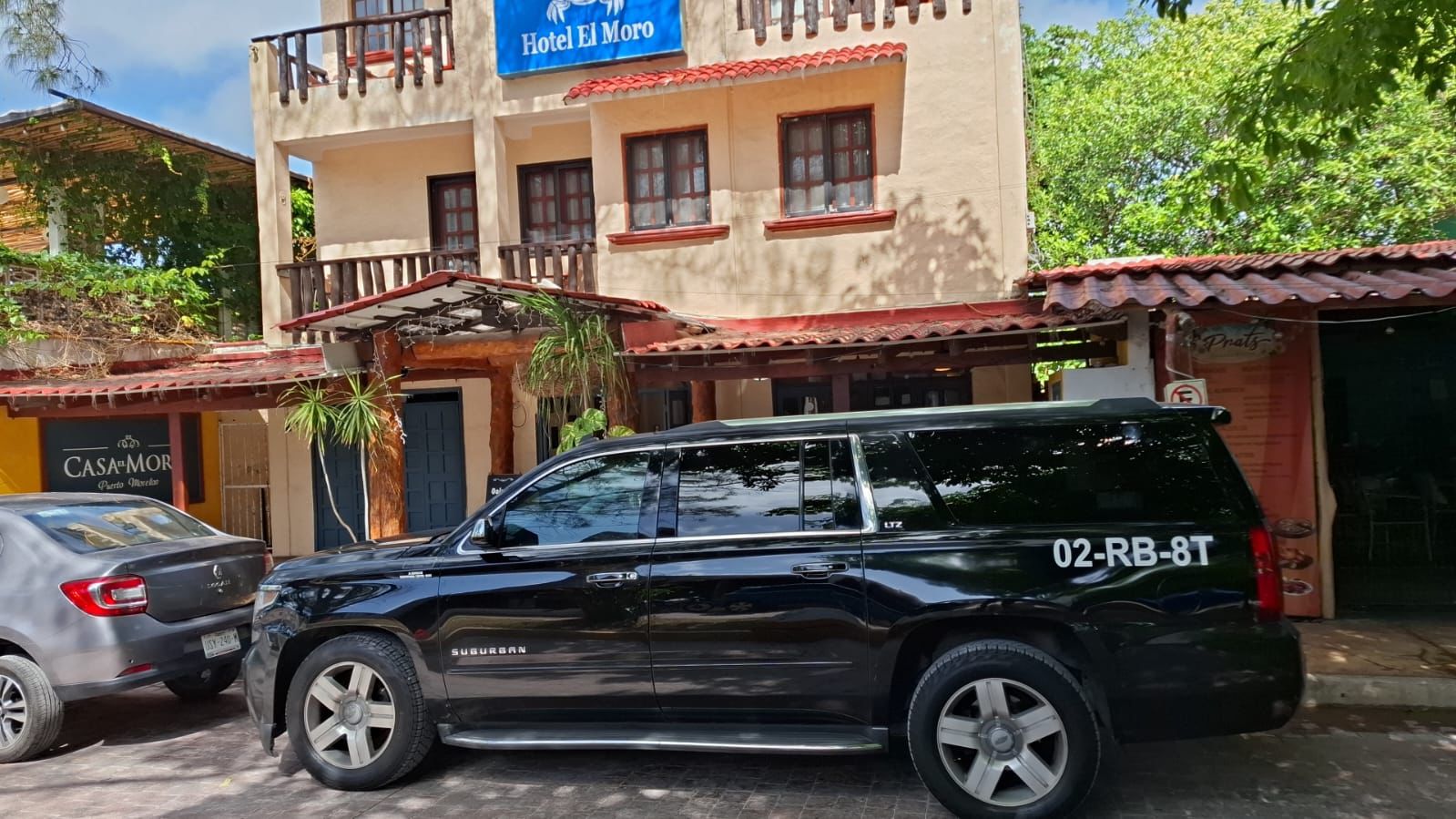Black Chevrolet Suburban parked outside a hotel in Riviera Maya for private transfer service.