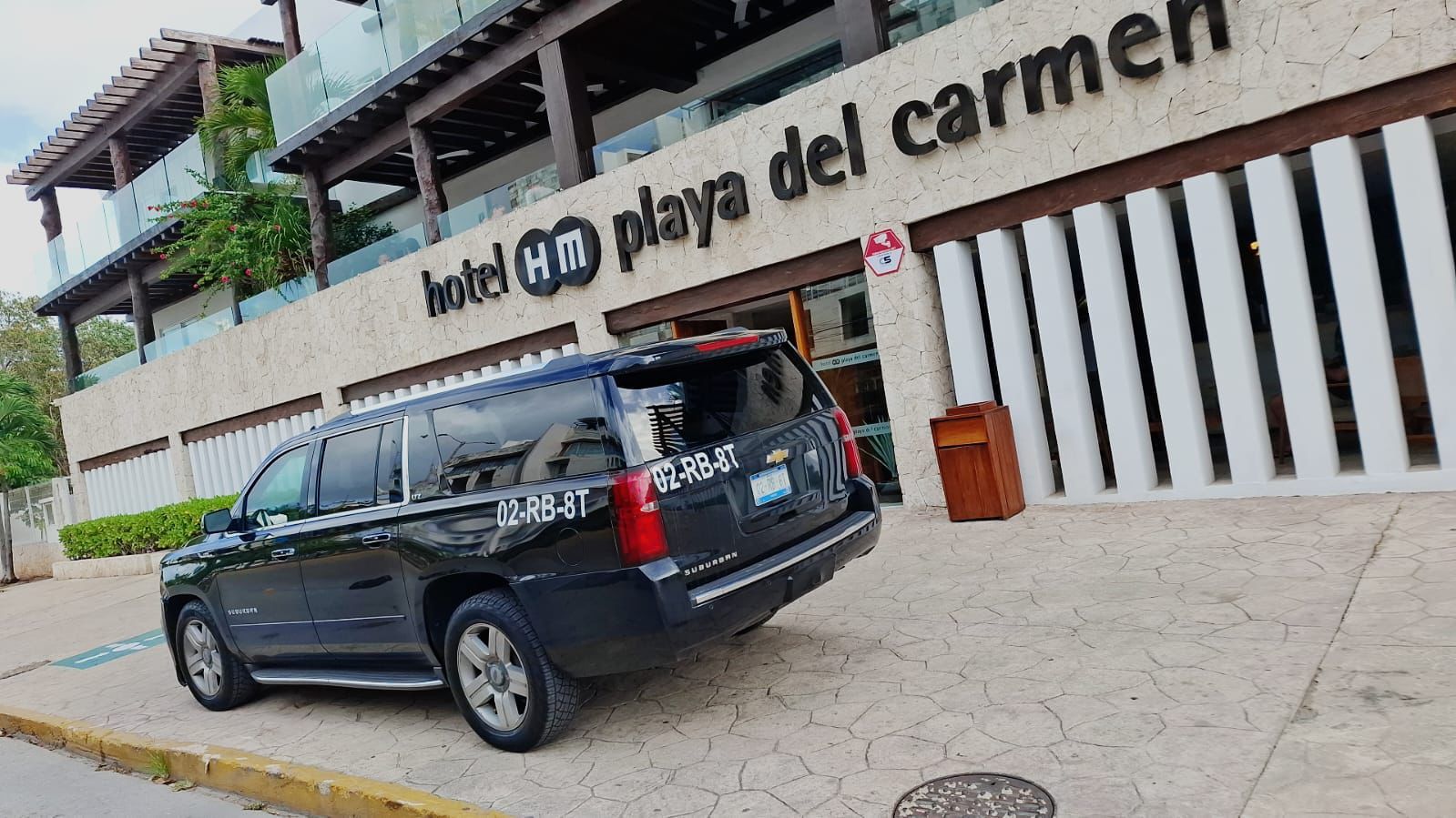 Black Chevrolet Suburban outside a Playa del Carmen hotel prepared for private transfer service.