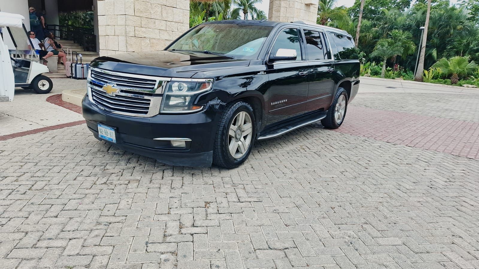 Black Chevrolet Suburban at a resort entrance for private arrival and departure transportation.